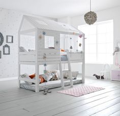 a white bunk bed sitting in a bedroom next to a pink dresser and mirror on the wall