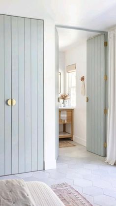 a bedroom with white walls and light blue closets in the corner, along with a rug on the floor