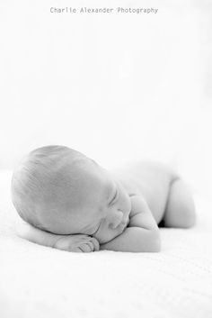 a black and white photo of a sleeping baby