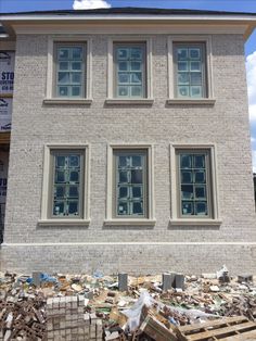 a building that is being built with wood pallets in front of it and several windows on the side