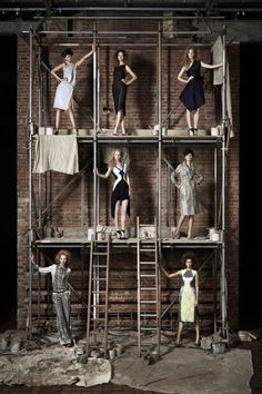 the models are posing on scaffolding in their dresses