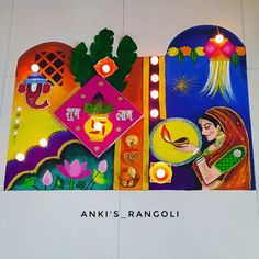 an artistic painting on the wall with candles lit up in front of it that reads, anni's rangoli