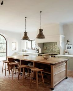 a kitchen island with stools in front of it