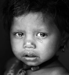 a black and white photo of a young child with teary eyes