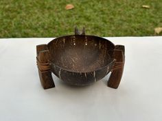 a wooden bowl sitting on top of a white table