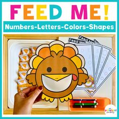 a hand holding up a piece of paper that says feed me numbers - letters - colors - shapes