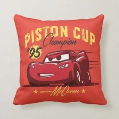 a red pillow with the words piston cup champion and a cartoon car on it's front