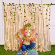 an elephant statue sitting on top of a table in front of a curtained window