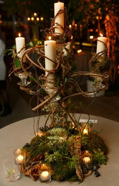 a table with candles and moss on it