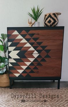 a wooden dresser sitting next to a potted plant