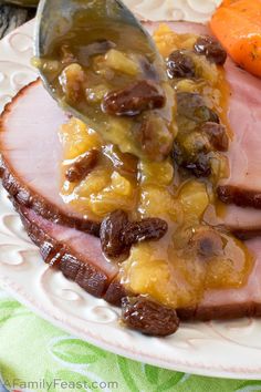 a plate topped with ham and fruit covered in gravy