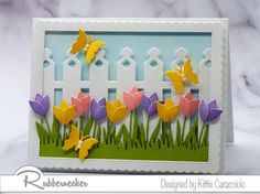 a card with flowers and butterflies in the grass, on top of a marble surface