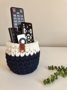 a knitted basket with remote controls in it