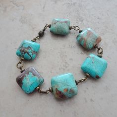 "Square turquoise magnesite beads are accented with antique brass beads, wire wrapped and linked along the length of this rustic southwest style bracelet.  Bracelet measures 8\" in length and has a magnetic closure.  If  you prefer a lobster claw closure just let me know with your order and I will make the change.   All of my jewelry items come boxed and lace ribbon tied and tagged for easy gifting.  This bracelet is ready to ship." Bracelets With Square Beads, Black Ribbon Choker, Turquoise Stone Bracelet, Aqua Necklace, Ribbon Choker Necklace, Hipster Gifts, Wire Wrapped Turquoise, Linked Bracelet, Red Beaded Bracelet