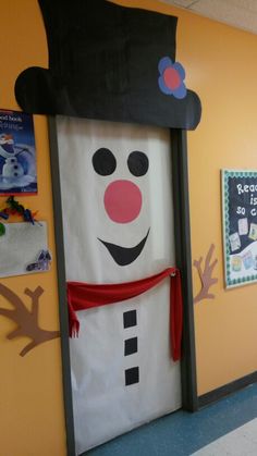 a classroom door decorated with a snowman's hat and scarf on the front