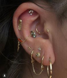 an ear with several different types of piercings on the top and bottom of it