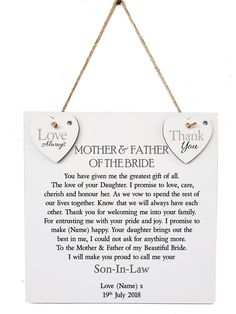 a hanging sign with two hearts attached to it that says, mother and father of the groom