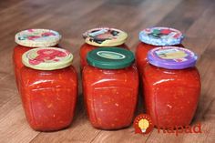 four jars filled with different types of sauce on a wooden table next to each other