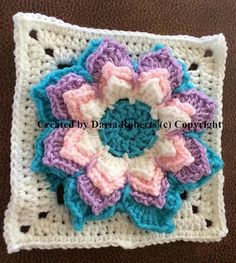 a crocheted square with a flower on it