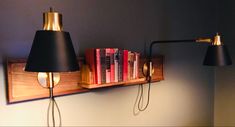 two lamps are on the wall next to a bookshelf with some books in it