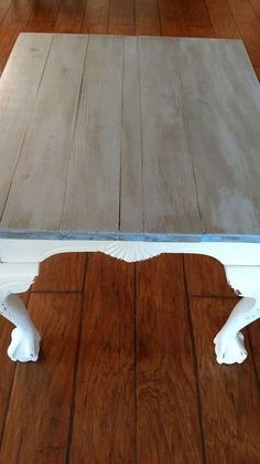 a white coffee table sitting on top of a hard wood floor