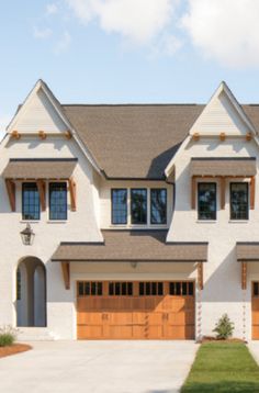 a large white house with two brown garage doors