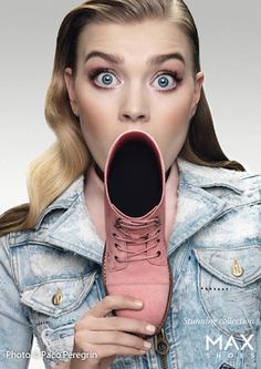 a woman holding a pink shoe in her mouth