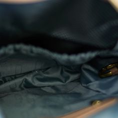 the inside of a blue purse with a gold ring in it's center pocket