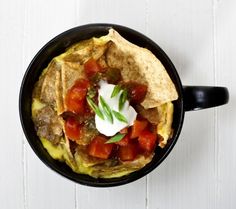 a black bowl filled with food on top of a white table