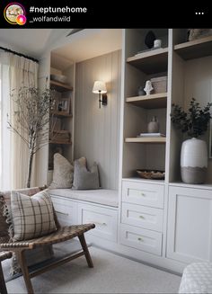 a living room with white furniture and shelves filled with vases, plants and other items