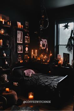 a dark bedroom with candles and pictures on the wall