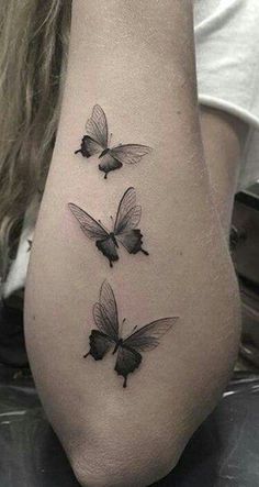 three butterflies tattoo on the left side of the leg, with one flying away from the other