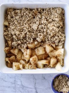 an apple crisp in a white dish next to a blue bowl