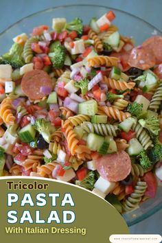 A colorful pasta salad with rotini, vegetables, cheese, and pepperoni slices.