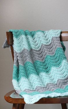 a crocheted blanket sitting on top of a wooden chair