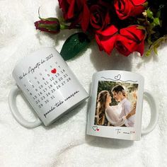 two coffee mugs sitting next to each other on a blanket with roses in the background