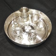 "Purity : 92.5 % silver Weight : 299 grams approx silver 190 gm - 1 pc thali - 7\" outer dia, 1\" height. 20 gm - 2 pc katori - 1.25\" dia, 1\" height. 38 gm - 1 pc bell - 2.75\" height 26 gm - 2 pc Diya - 1\" dia, 1.25\" height 25 gm - 1 pc Loti - 1.25\" dia , 2\" height" Silver Pooja Thali, Malabar Jewellery, Nail References, Silver Payal, Silver Plates, 22k Gold Earrings, Bridal Anklet, Pooja Thali, Pooja Items