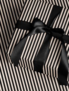 a black and white striped gift box with a bow