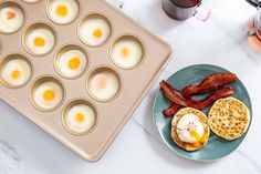 eggs and bacon are in muffin tins on a plate next to a cupcake pan