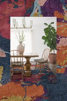 a dining room table with chairs and a potted plant in the middle on an area rug