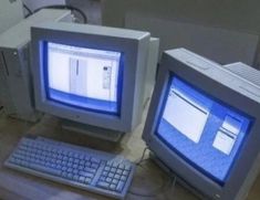 two old computer monitors sitting next to each other