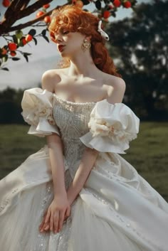 a woman with red hair wearing a white dress and holding her hand on her hips