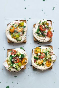 four pieces of bread with different types of food on them