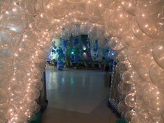 an archway decorated with balloons and streamers for a party or wedding reception at night