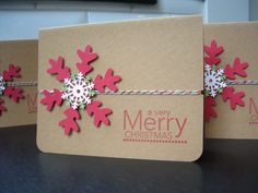 three christmas cards with red and white snowflakes on them, tied in twine