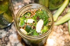 a mason jar filled with green vegetables and other things on top of a granite counter