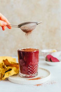 someone is sprinkling spices into a cup