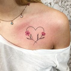 a woman's chest with flowers in the shape of a heart on her left shoulder