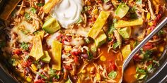 a crock pot filled with chicken tortilla soup and topped with sour cream