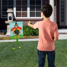 a young boy is painting a turkey on the lawn